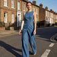 Ermeløs asymmetrisk omslags denim jumpsuit for kvinner