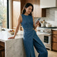Ermeløs asymmetrisk omslags denim jumpsuit for kvinner